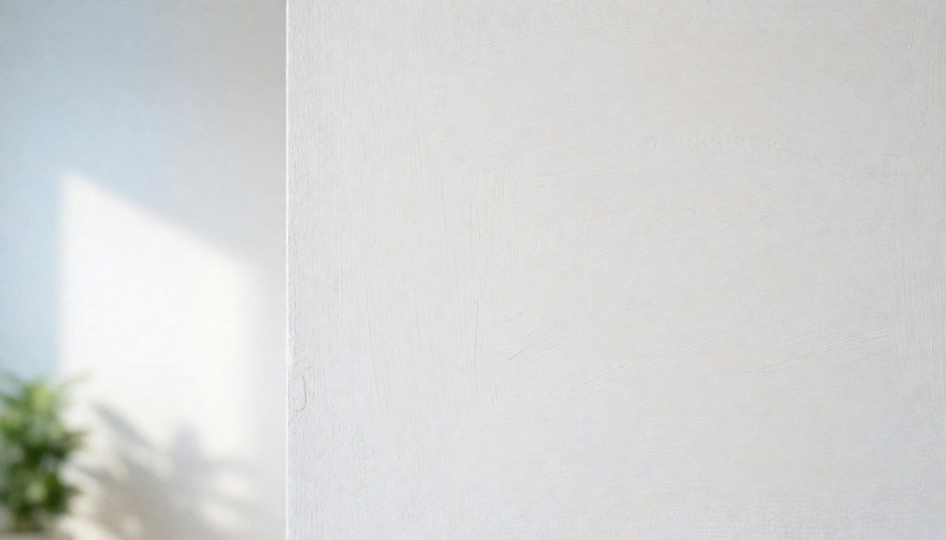 Close-up view of a clean white painted wall with subtle texture, serving as a minimalist background suitable for commercial text overlays and business presentations.