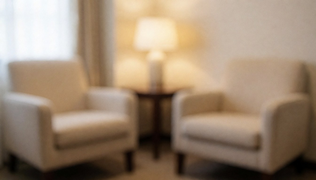 Neutral consultation room background featuring two comfortable chairs and a lamp, ideal for text overlays and professional presentations.