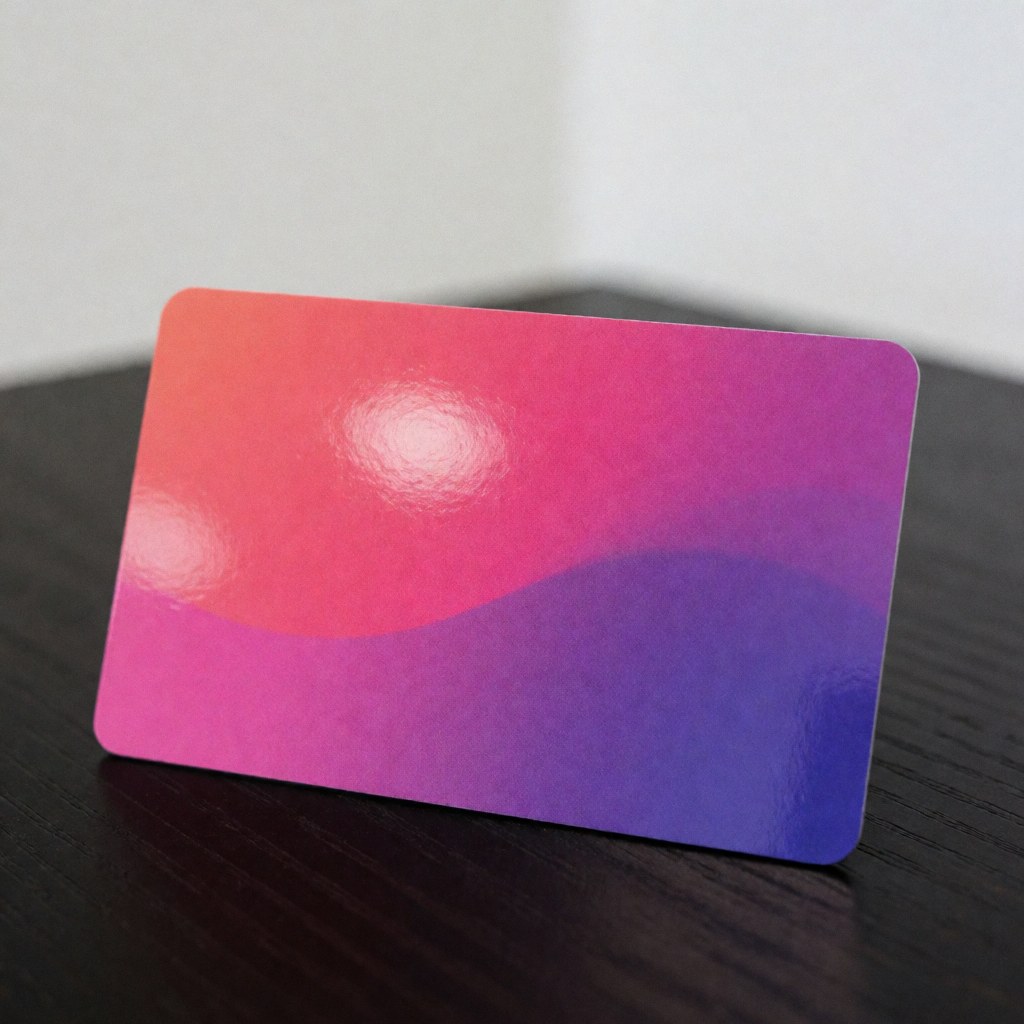 A vibrant prepaid card with a pink and purple gradient design resting on a wooden surface with a white background and subtle reflections