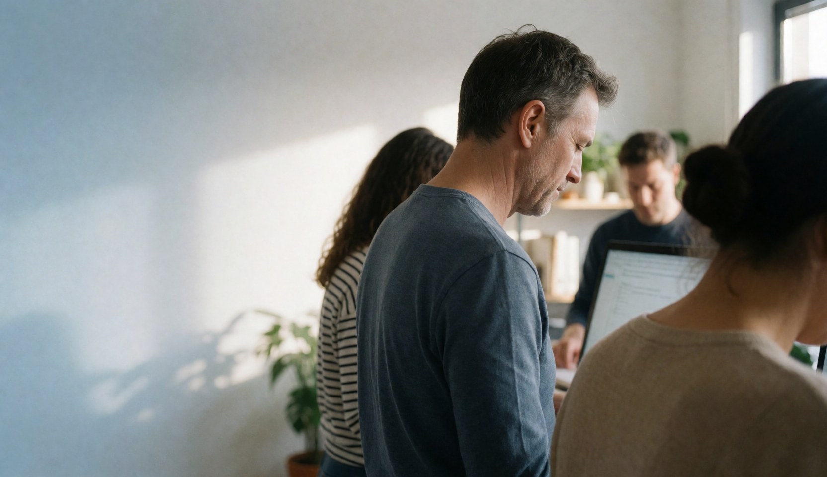 A real estate team working together at desks in a bright modern office with natural light and plants