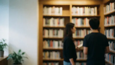 Rows of bookshelves in a library featuring warm light, white walls, and green plants, serving as a calm background for text and design.