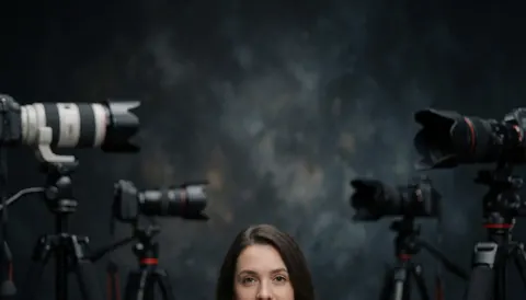 A professional photography studio featuring multiple cameras mounted on tripods against a dark, textured background, ideal for artistic and commercial use.