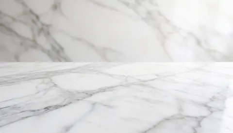 Close-up view of a white and gray marble surface with natural veining patterns, serving as an elegant background for real estate marketing materials.