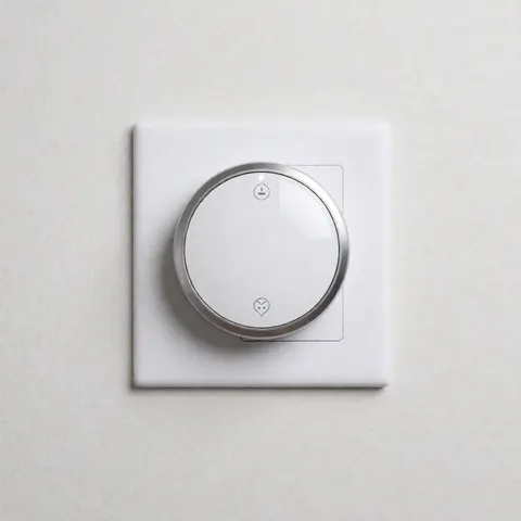 A sleek smart thermostat mounted on a white wall in a contemporary bathroom, featuring minimalist design and modern technology for home energy efficiency.