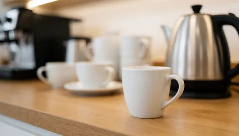 Soft focus warm background featuring a coffee cup and kettle on a wooden surface, ideal for text overlay in language school materials