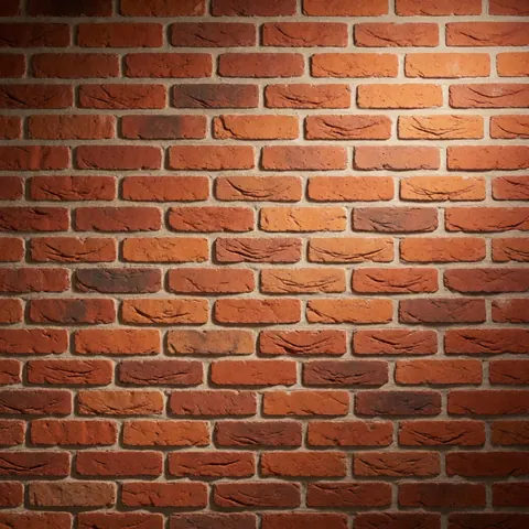 A close-up view of a rustic brick wall with warm lighting and visible texture, suitable for landscaping and interior design backgrounds.