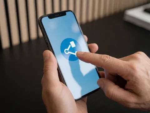 Close-up of a hand touching a smartphone screen to share a link, symbolizing online education and digital learning for business courses