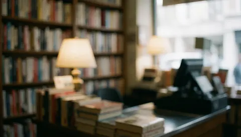 A soft focus view of a wooden bookstore counter with books and a small lamp, creating a calm atmosphere for text overlay