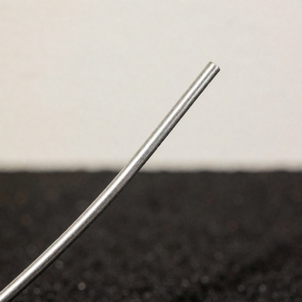 Detailed view of lead-free soldering wire with a metallic shine against a dark textured background, highlighting the material used in professional plumbing work.