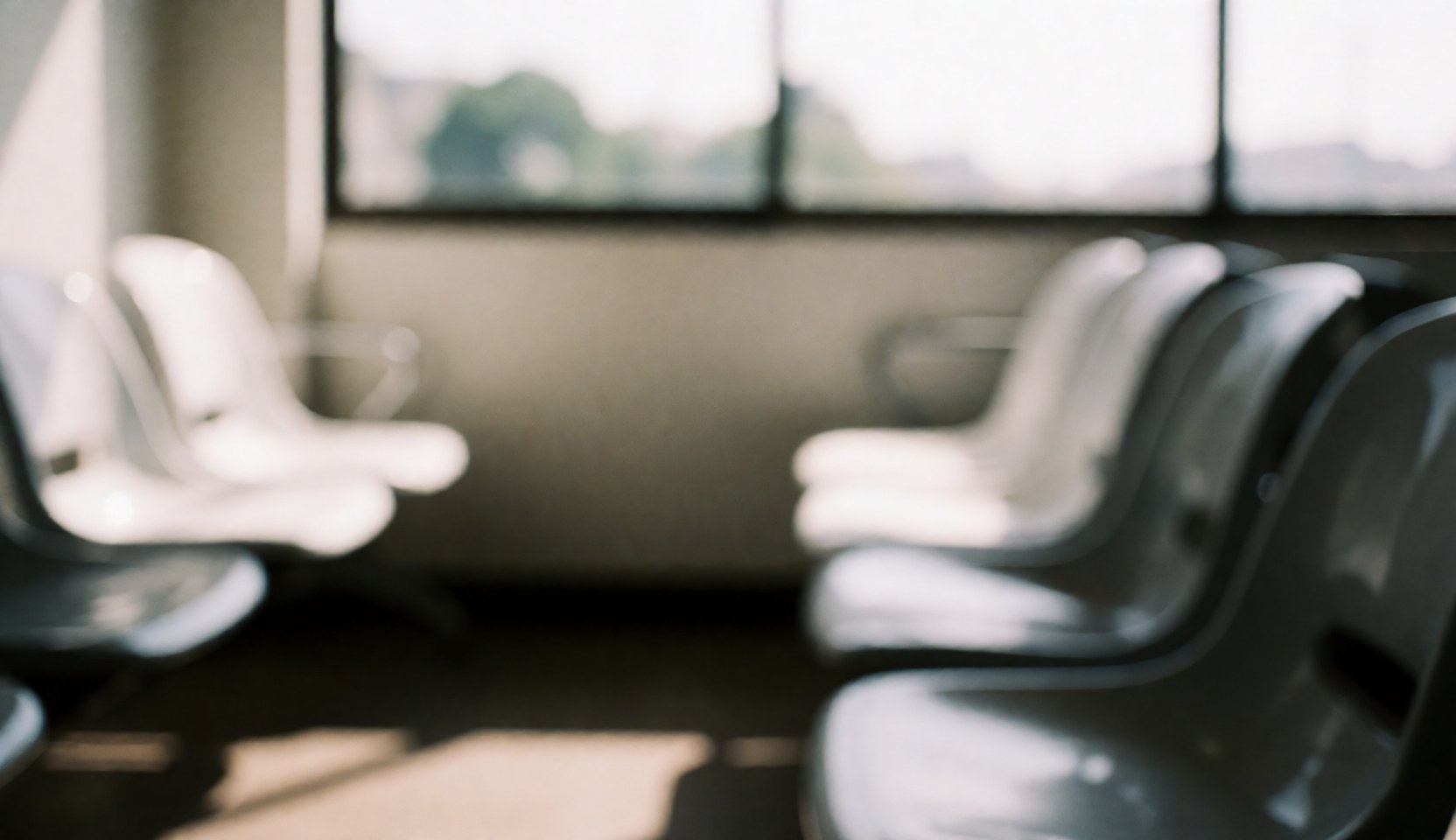 A calm waiting area interior featuring rows of gray plastic chairs near a window, providing a neutral background for text overlays in fast food or restaurant contexts