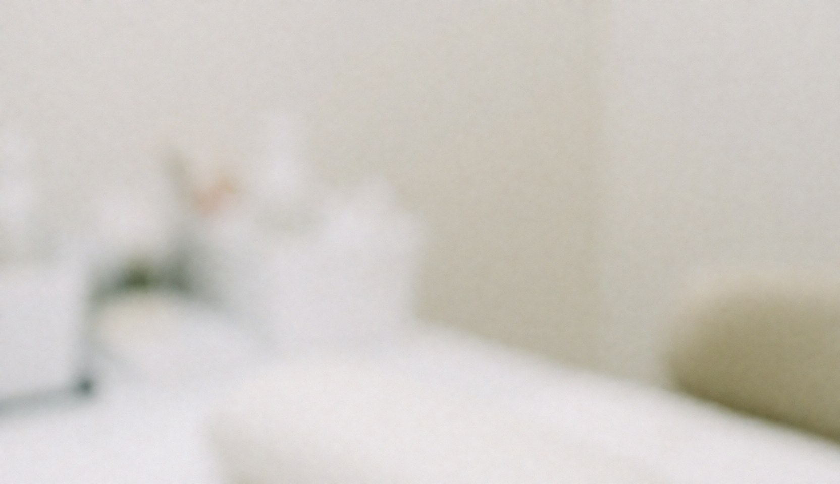 A serene and clean nail salon interior featuring white and cream tones, wooden furniture, and soft lighting, ideal as a professional text background.