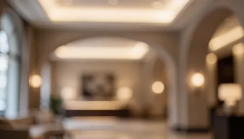 Soft focus beige and taupe hotel lobby interior with warm ambient lighting and bokeh effects, ideal for text overlay