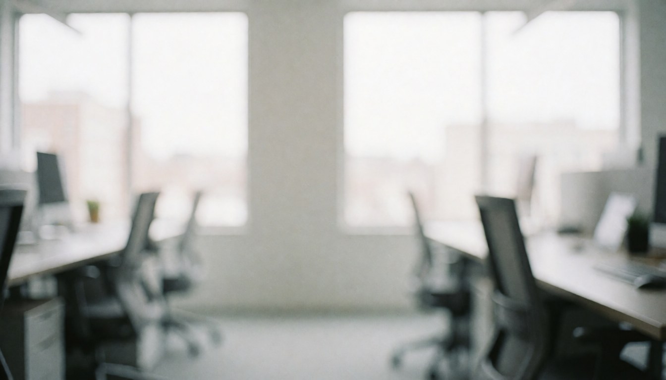 A bright and airy modern office desk with a chair near a window, featuring natural light and a blurred professional background suitable for text overlay.