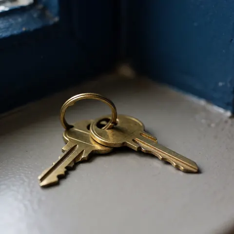 A detailed close-up view of a bronze metal house key, highlighting its secure design for home protection and access control.