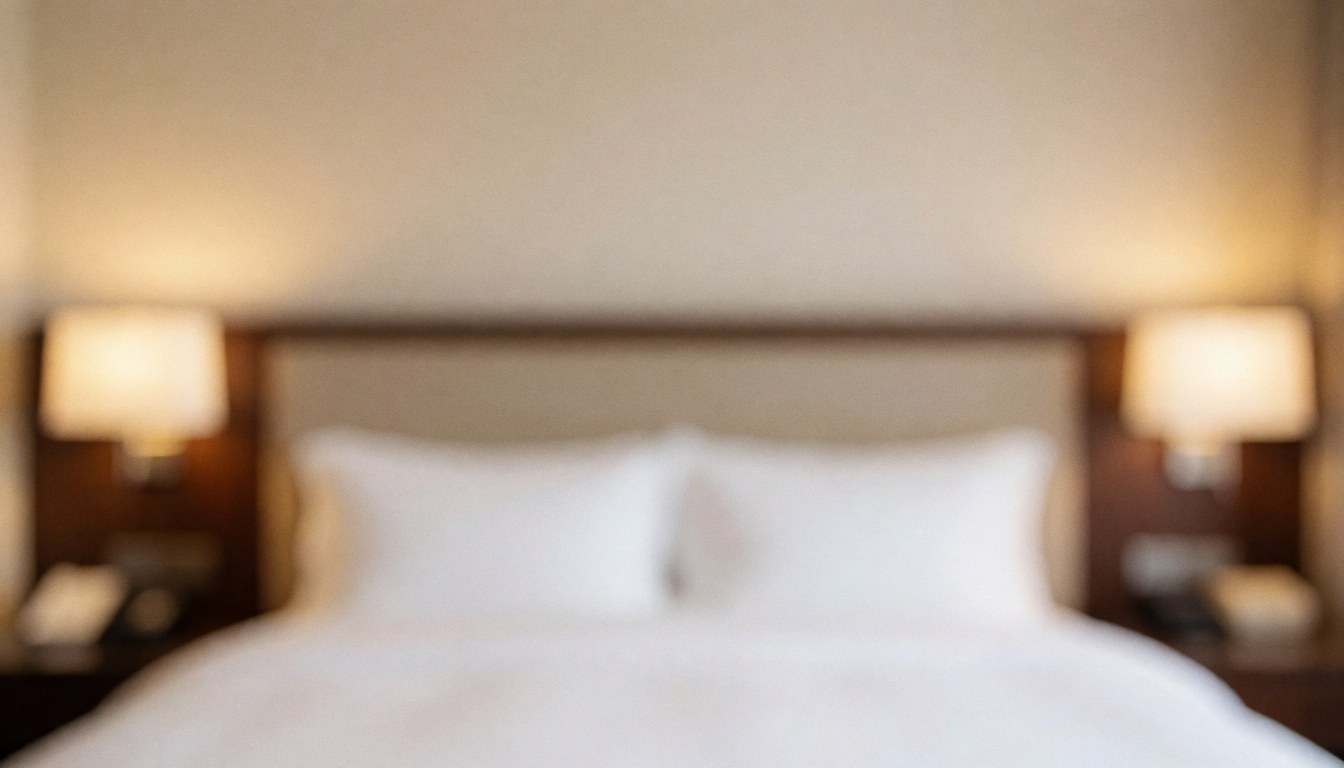 Close-up of a hotel bed with warm lighting, ideal for promotional text, conveying comfort and luxury.