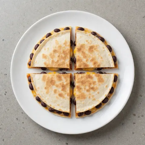 A freshly sliced black bean quesadilla with melted cheese served on a white plate, showcasing a delicious fast food option.