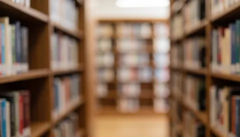 A warm-toned library background featuring wooden bookshelves filled with books, ideal for text overlay in university or educational contexts