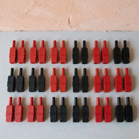 Top-down view of black and red mc4 solar connectors arranged on a textured gray surface with natural lighting, ideal for solar energy product displays.
