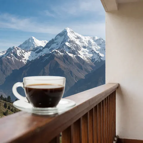 A coffee cup sits on a wooden terrace overlooking snow-capped mountains and a blue sky, suitable for a university campus setting.