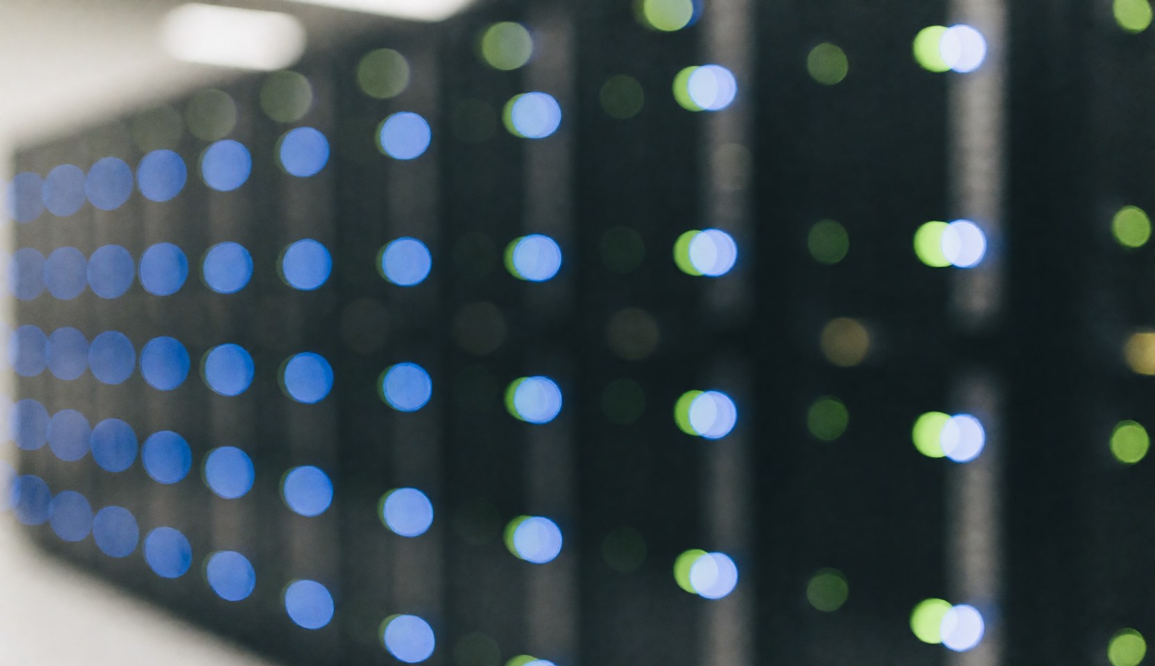 Blurred blue and green lights in a datacenter server room, creating a calm tech atmosphere for software and startup text overlays
