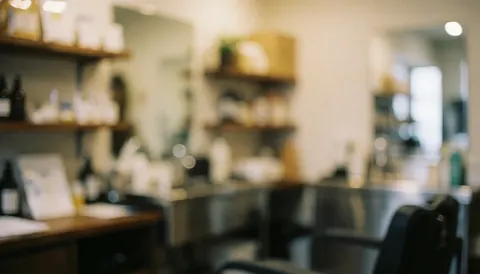 Softly blurred background of a professional dog grooming salon featuring stainless steel tables, wooden shelves, and warm lighting suitable for text overlays.