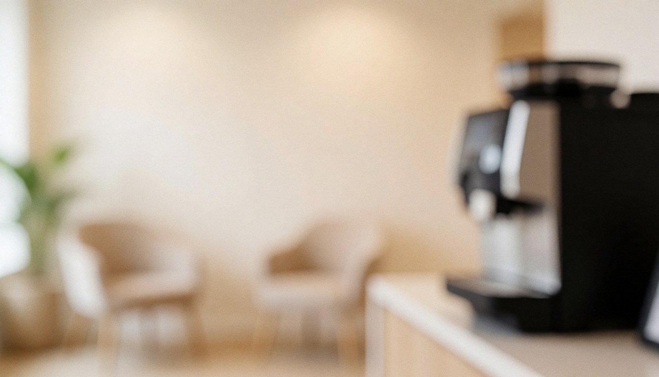 Soft focus photo studio background featuring chairs and a coffee machine, providing a neutral warm surface ideal for overlaying commercial text.