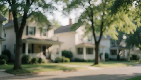 A serene residential street background featuring houses, trees, and greenery with soft bokeh lighting suitable for text overlay