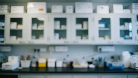 Out of focus lab background featuring white shelving units, storage boxes, and scientific instruments, suitable for professional text overlays and presentations.