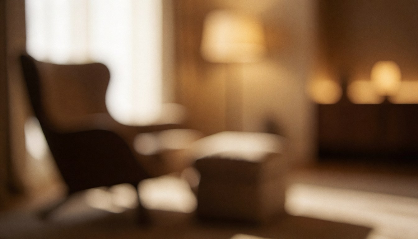 Softly lit interior of a tranquil massage room featuring a comfortable chair and bed, creating a calm atmosphere for therapeutic treatments and wellness services