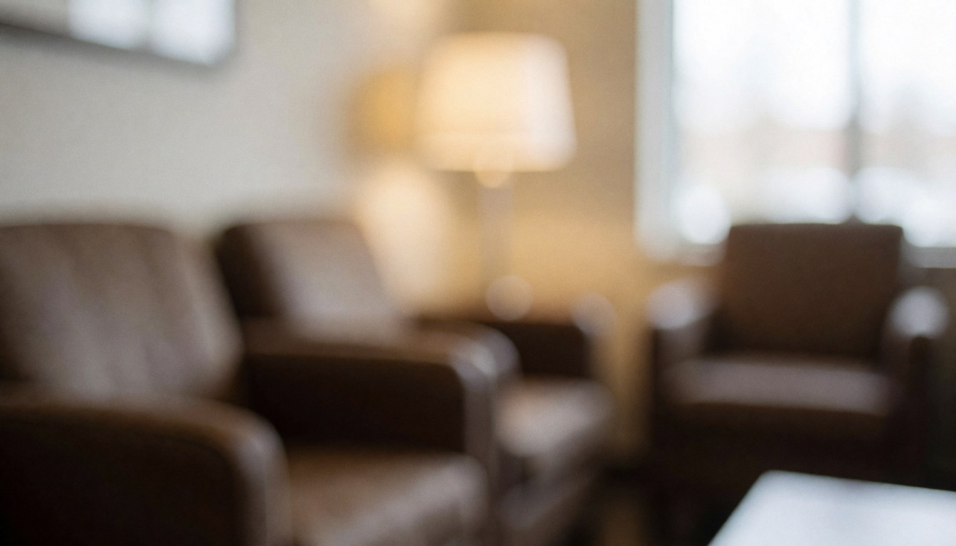 A tranquil waiting area featuring comfortable chairs and a lamp, creating a relaxing ambiance with soft light and blurred tones for text backgrounds
