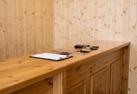 Polished wooden counter in a shoe store with tools and notebook, wood panel walls, clean and professional atmosphere