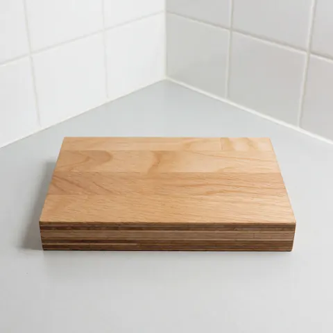A clean wooden cobbler block resting on a white tiled surface with natural lighting, used for shoe repair and craftsmanship.