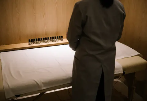 A serene Tui Na massage room featuring a wooden treatment table, essential oils, and warm ambient lighting for relaxation