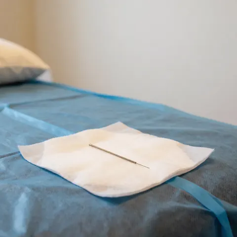 A water bottle for acupuncture therapy placed on a clean treatment table with a sterile cloth, set in a professional environment ideal for recovery.