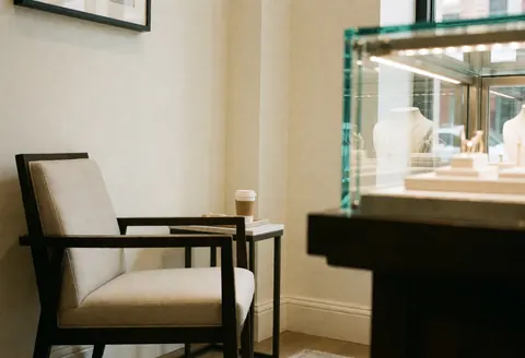 Modern chair and jewelry counter in a bright, professional store with natural light and elegant decor
