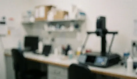 Soft focus background of an orthopedic lab featuring a desk, shelves, and medical equipment. Ideal for professional and clean text overlays.