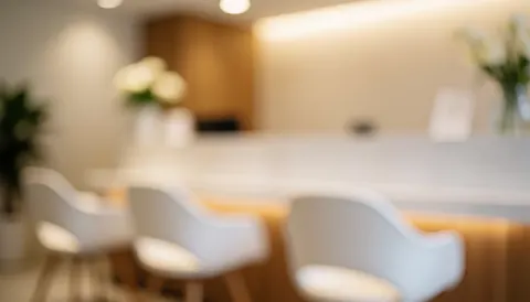 Soft focus background of a modern podiatry clinic reception with a wooden desk, chairs, plants, and warm lighting suitable for text overlay