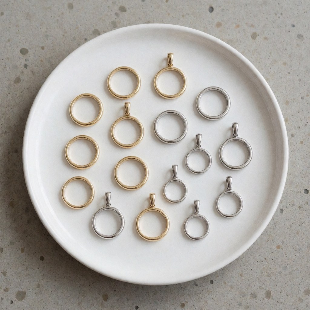 Close-up view of gold and silver jewelry pieces arranged on a concrete surface for product display and comparison purposes