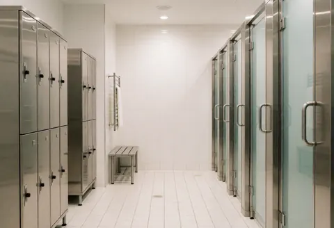 A hygienic changing area featuring stainless steel lockers and benches, designed for advanced physiotherapy and hydrotherapy facilities.