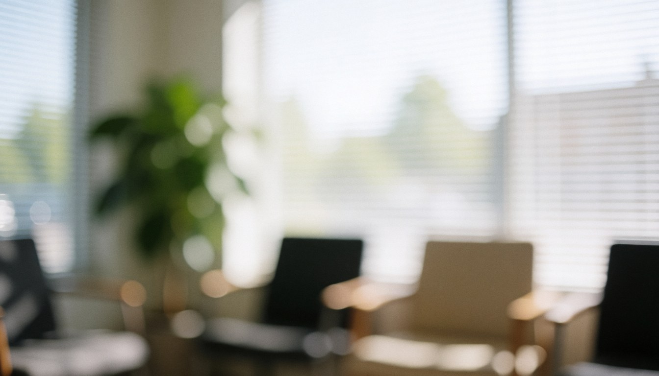A blurred background of a quiet waiting area featuring chairs, plants, and windows with natural light, suitable for text overlay