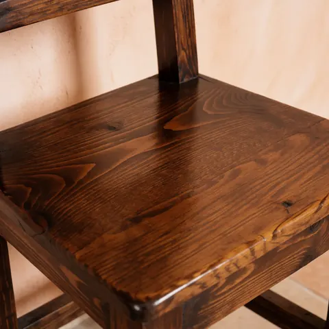 Close-up view of a restored cedar chair showcasing natural wood grain, knots, and a polished finish suitable for furniture repair services