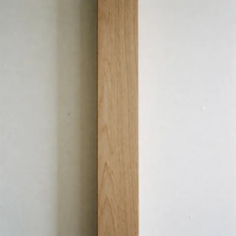 Close-up view of a repaired wooden furniture piece showing the final result with a clean, treated surface ready for use.