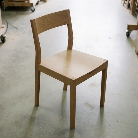 A restored Shaker style wooden chair with clean lines and natural wood finish, suitable for dining or office use.
