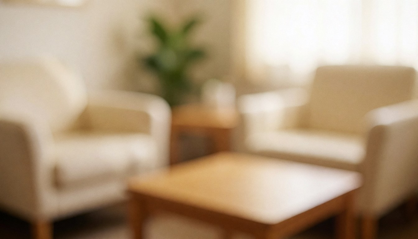 Beige armchairs and wooden table in a warm, calm osteopathy waiting room with a plant and soft lighting.