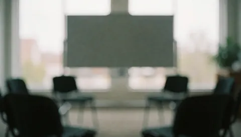 Blurred background of a serene reiki training room featuring chairs arranged in a circle and a whiteboard, ideal for holistic health and wellness text overlays.