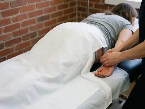 A close-up view of a specialized massage table designed for pregnant women, featuring a cutout section for abdominal safety and comfortable positioning during prenatal therapy sessions.