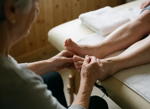 Detailed close-up view of a pregnant woman's feet receiving a relaxing foot massage with oil, highlighting care and wellness for expectant mothers.