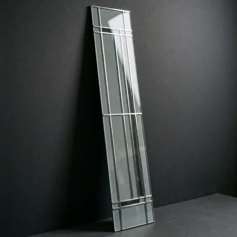 Close-up of a linear geometric decorative glass panel with a black metal frame, showcasing minimalist modern design and reflective surfaces for interior decor.