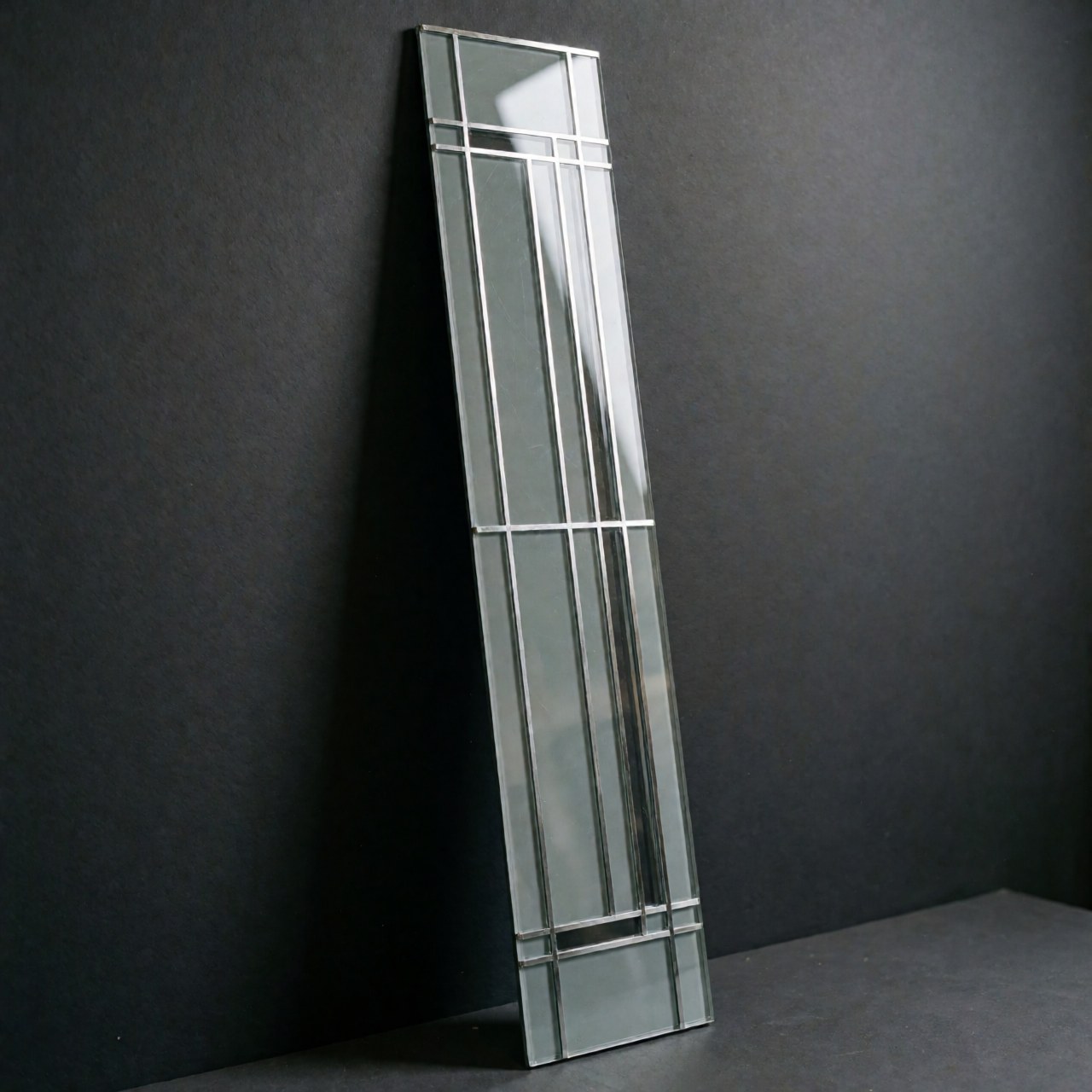 Close-up of a linear geometric decorative glass panel with a black metal frame, showcasing minimalist modern design and reflective surfaces for interior decor.