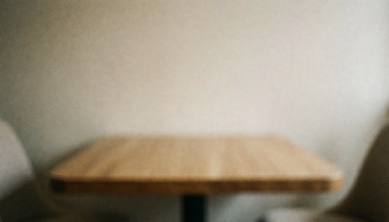 A wooden table set against a soft beige wall with a blurred background, creating a calm and professional space ideal for reflexology consultation text overlays.